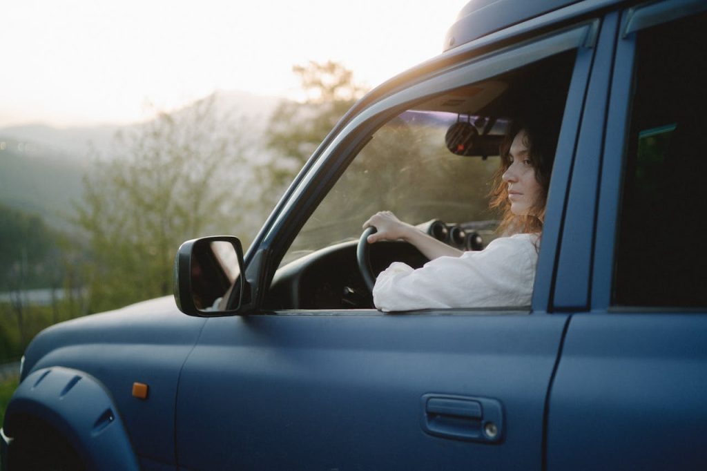 pexels photo 8028280 A woman driving an SUV through a scenic outdoor landscape at sunset, capturing adventure and exploration.